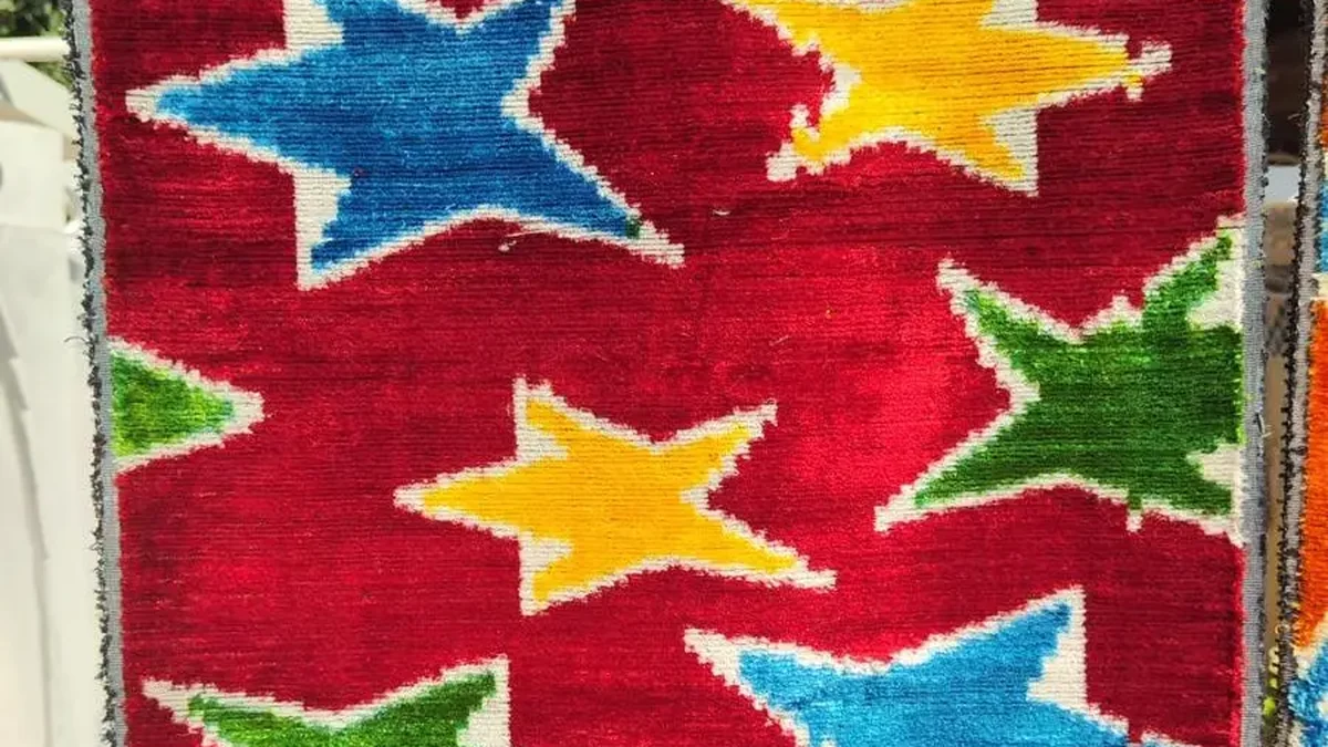 Ikat-Samt in Rot mit eingewebten Sternen in Blau, Gelb und Grün