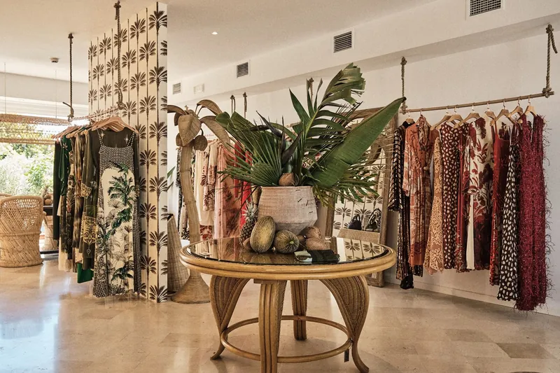 Sommerboutique im Marbella Club mit bedruckten Kleidern, Pflanzen und Rattanmöbeln