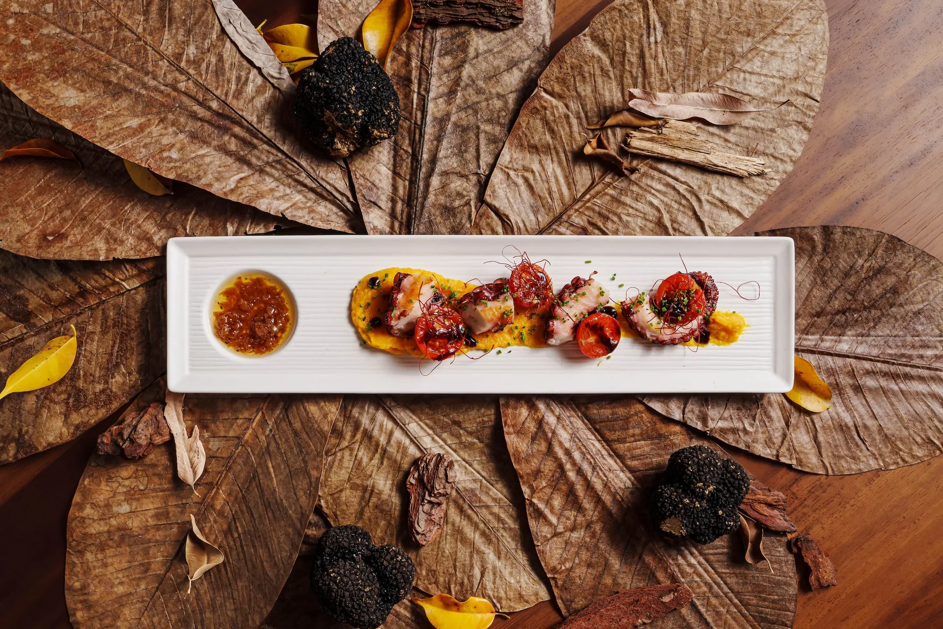 Gang des Herbst-Omakase im Nobu Hotel Marbella, angerichtet auf getrockneten Blättern