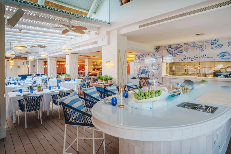 Speisesaal des Sea Grill im Puente Romano Marbella mit weißer Seafood-Bar und blau-weißen Fliesen